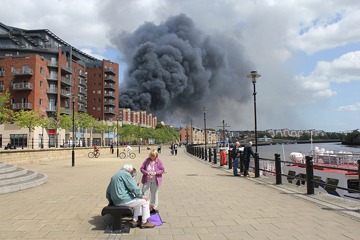 Your Pictures: Alight: Smoke from a fire in the background with no-one paying any attention