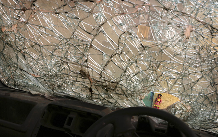 20 Photos: An Indian girl is seen through the broken window of an abandoned car