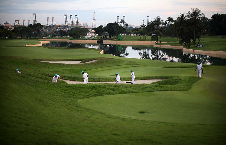 24 hours: Singapore: Workers prepare the golf course at the Singapore Open