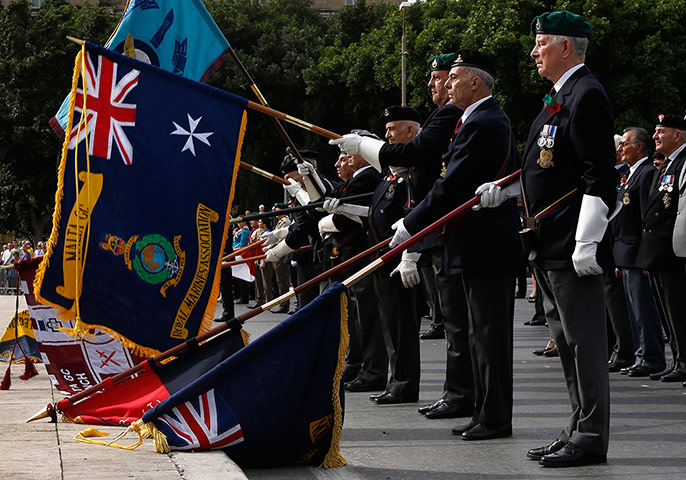 Remembrance Day: Valletta, Malta: War veterans raise their flags after two minutes silence