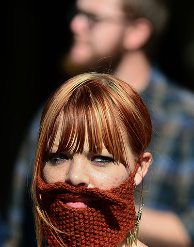 Moustache competition: A woman in the crowd wears a fake beard