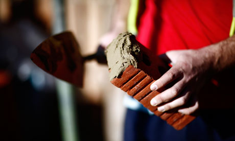 A bricklayer gets ready to lay a brick