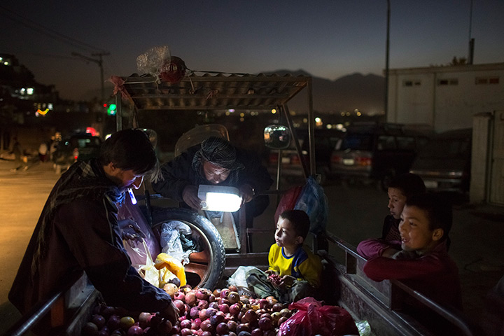24 hours: Kabul, Afghanistan: Afghan children watch a customer 