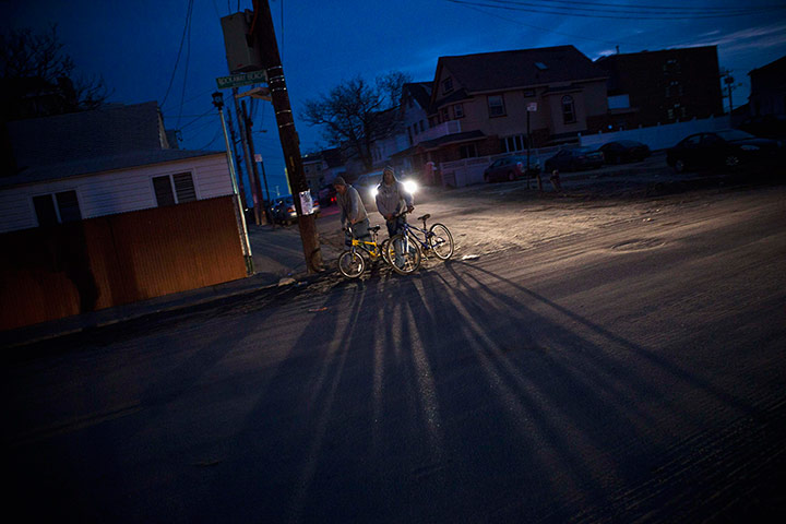 Hurricane Sandy clean-up: Men push bicycles through the Rockaway Beach neighborhood of Queens