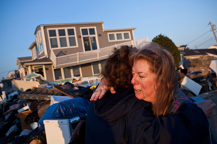 Hurricane Sandy clean-up: Evelyn Faherty hugs a friend while discussing the damage to her home
