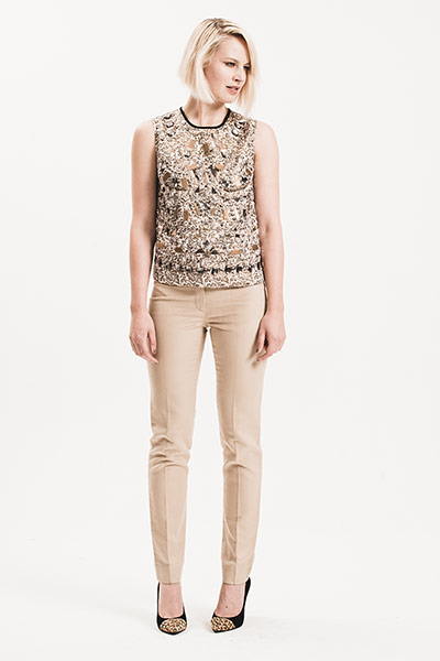 All Ages: Shiny: model wears embellished gold sleeveless top and camel trousers