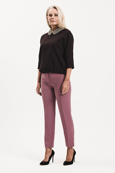All Ages: Shiny: model wears black top with embellished collar and pink trousers