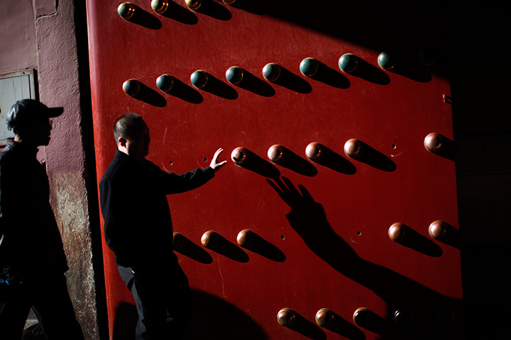 Carlos Barria China: A man touches an entrance door of the Forbidden City