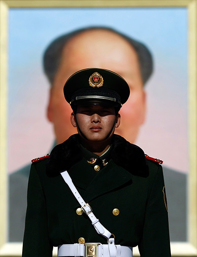 Carlos Barria China: A paramilitary policeman stands guard in front of a portrait of Mao Zedong