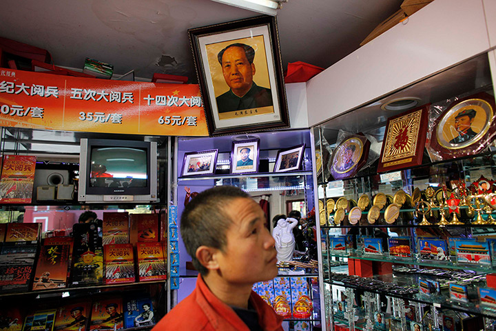 Carlos Barria China: A man walks under a portrait of former Chinese leader Mao Zedong shop