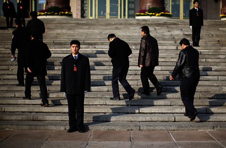 Carlos Barria China: Security guards keep watch as delegates walk the Great Hall of the People