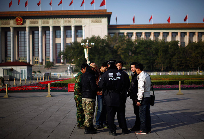 Carlos Barria China: A police officers check identifications cards in Tiananmen Square