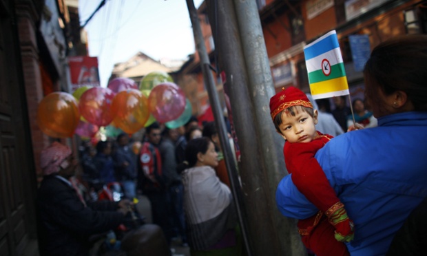 A young ethnic Newari boy is carried by his mother as they watch a parade to celebrate their New Year in Katmandu, Nepal. Members of the Newar community celebrated their New Year's Day by praying for longevity and performing rituals to purify and empower the soul for the coming year.