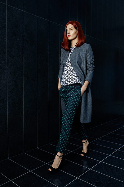 Fashion: Illusions: model wearing geometric top and trousers and a grey coat