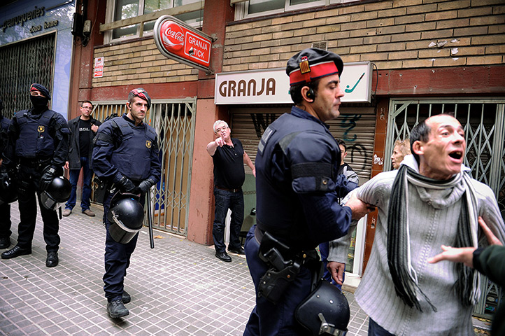 Euro protests: Barcelona, Spain: Riot police protect a restaurant owner