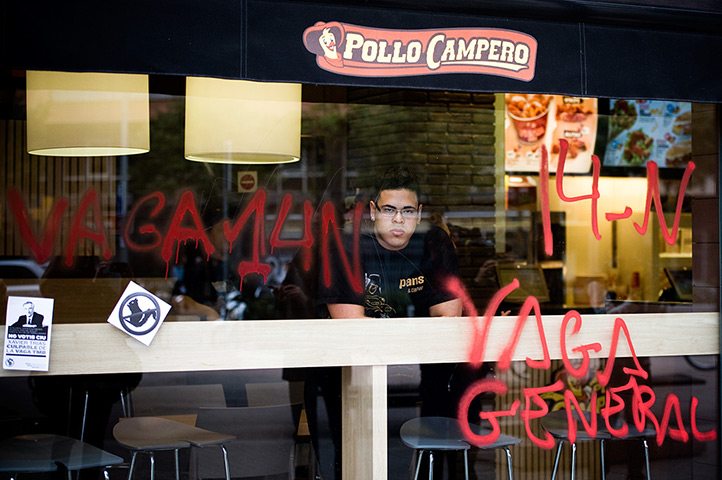 Euro protests: Barcelona, Spain: An employee of restaurant looks through  window