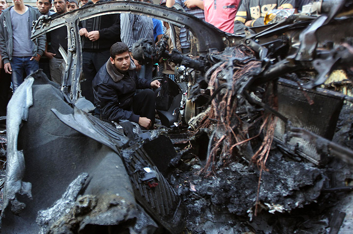 Hamas Ahmed al-Jaabari: A Hamas policeman checks a destroyed car of Hamas's military chief