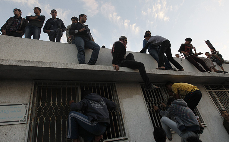 Hamas Ahmed al-Jaabari: Palestinians look inside a building where the body of Ahmed al-Jaabari
