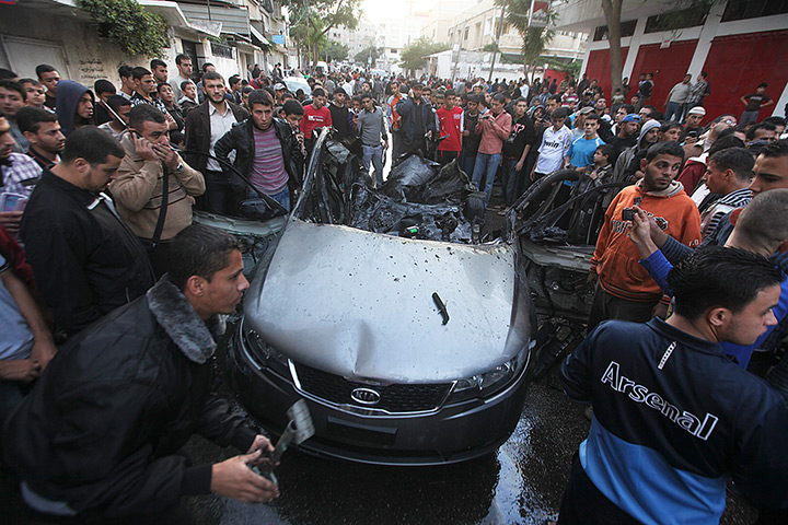 Hamas Ahmed al-Jaabari: A crowd is seen observing the remains of the burned out destroyed car