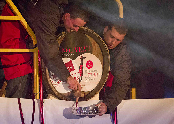 Beaujolais Nouveau: Men tap wine from a barrel