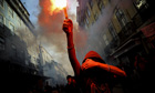 A protestor holds a flare during anti-austerity demonstration in Lisbon