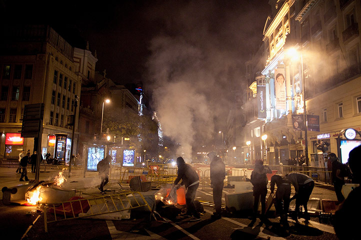 Europe protests: Demonstrators make a barricade during clashes with police in Madrid, Spain