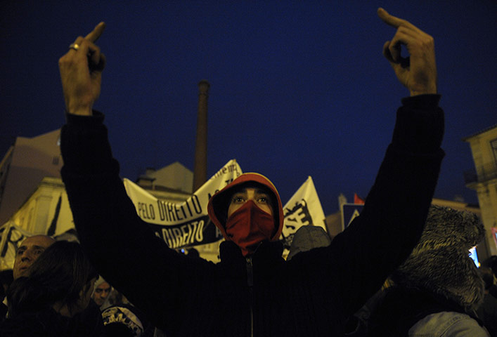 Europe protests: A protester gestures at police during a demonstration in Lisbon
