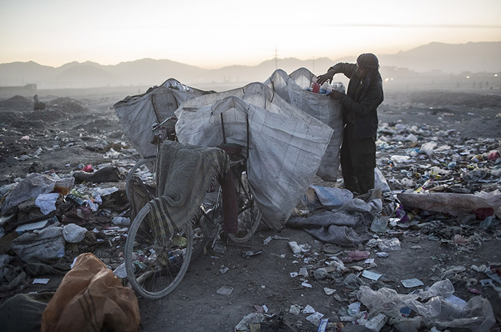 24 hours in pictures: An Afghan Pashtun boy scavenges for recyclables at a garbage dump