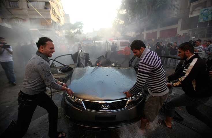 Gaza and Israeli strikes: Gaza city: Palestinians try to remove the remains of a car