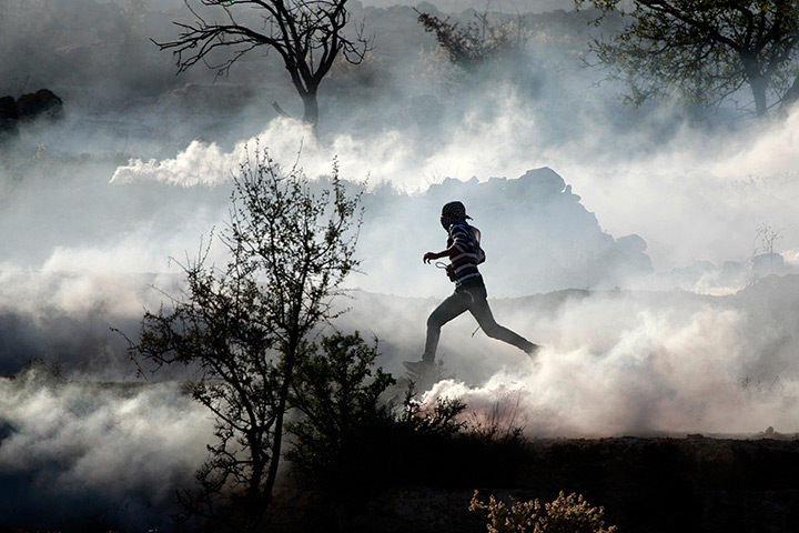 Strikes update: Gaza Strip: A Palestinian demonstrator runs through a cloud of tear gas