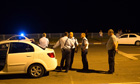 Israeli policemen stand at the sea front near where a rocket landed in the sea