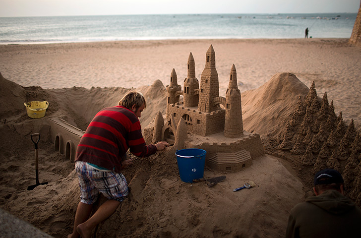 24 hours in pictures: A man works on his sand castle in spain