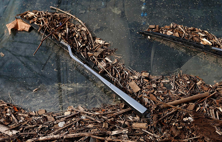20 Photos: Debris hangs on a car submerged by flooding caused by superstorm Sandy