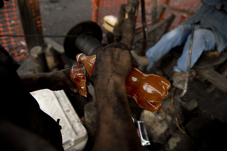 20 Photos: A Mexican miner pours hot chili sauce into his food
