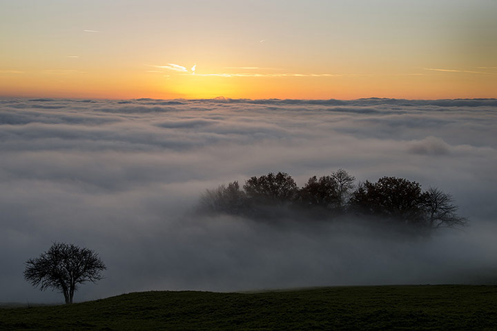24 hours: sunset surrounded by heavy fog hanging above Lake Geneva