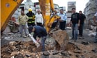 An Israeli policeman pulls a rocket launched from Gaza out of the ground in Netivot