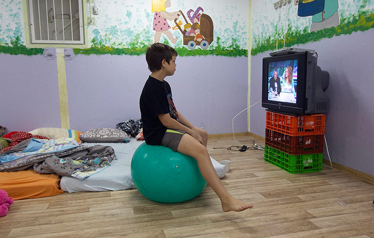 Gaza: An Israeli boy watches television inside a bomb shelter at Kibbutz Reim