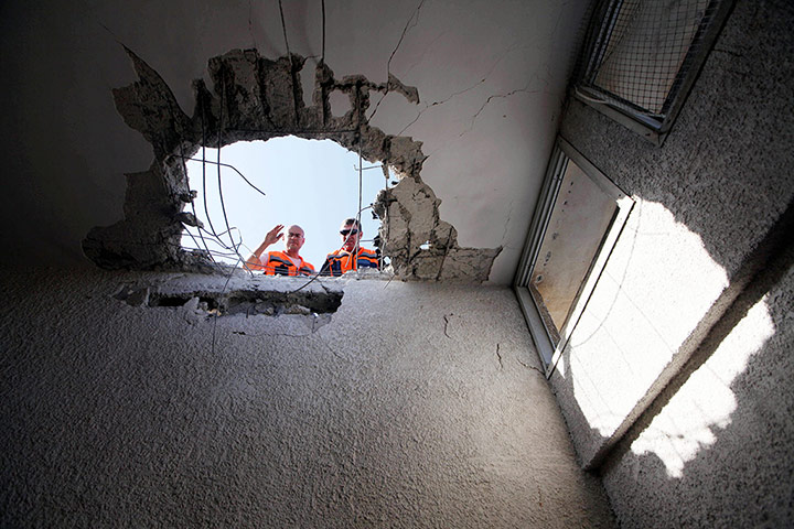 Gaza: Israeli security personnel assess the damage on the ceiling of an apartment