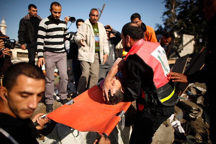 Gaza: Members of the Palestinian Civil Defense carry a survivor