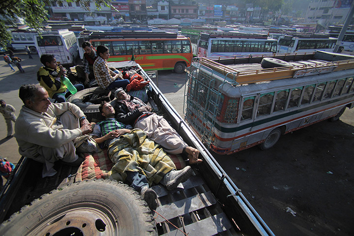24 hours: Jammu, India: Stranded passengers rest on top of a parked bus