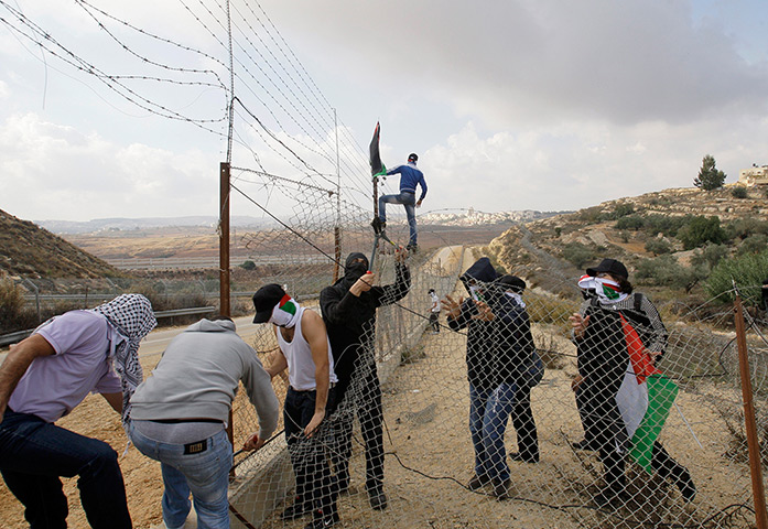 Gaza conflict: Palestinian protesters cut a section of the West Bank separation barrier 