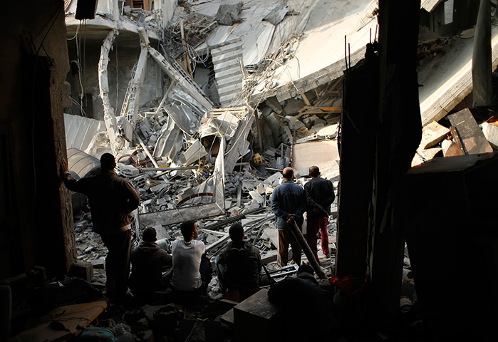 Gaza conflict: Palestinians look at a destroyed house after an Israeli air strike in Gaza
