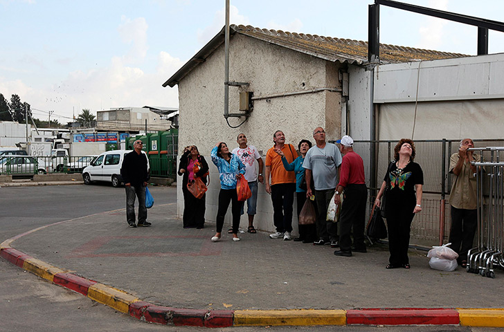 gaza conflict continues: Israelis look up as a siren signals warns of incoming rockets in Ashkelon 