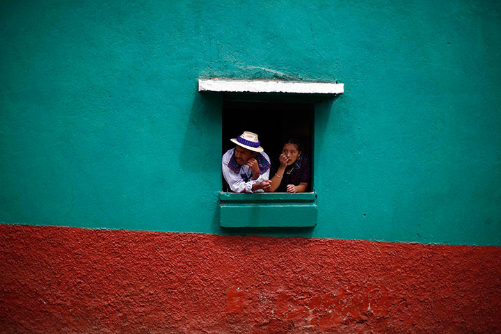 24 hours: Huehuetenango, Guatemala: People look out of a window