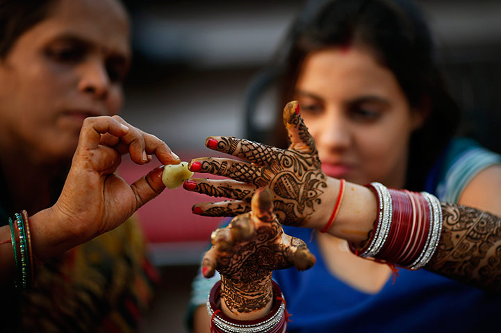 24 hours: New Delhi, India: A Hindu woman has traditional designs painted