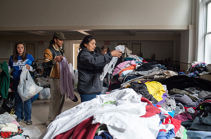 Superstorm sandy supplies: A woman searches a pile of donated clothing 