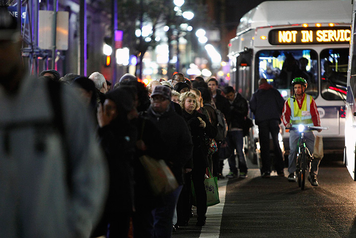 Superstorm sandy supplies: People line up on along a street in Manhattan to take buses