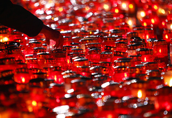 Day of the dead: A man lights candles during All Saints Day at cemetery Mirogoj