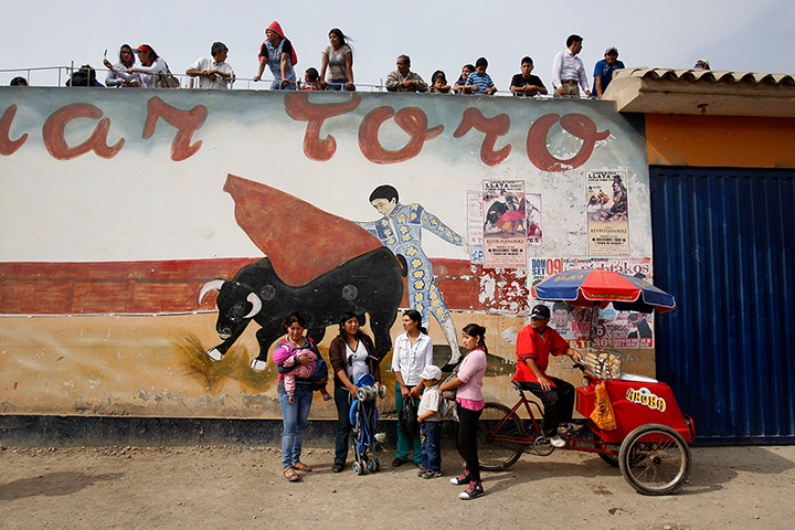 24 hours: Lima, Peru: People watch a parade outside a bullfighting ring