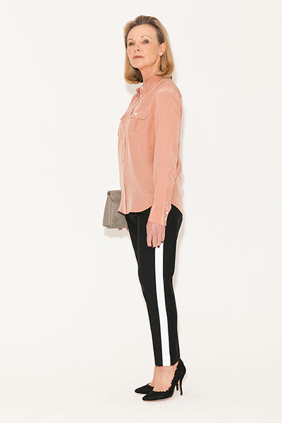 All Ages: Trousers: Model wears black trousers with a white stripe and a peach shirt